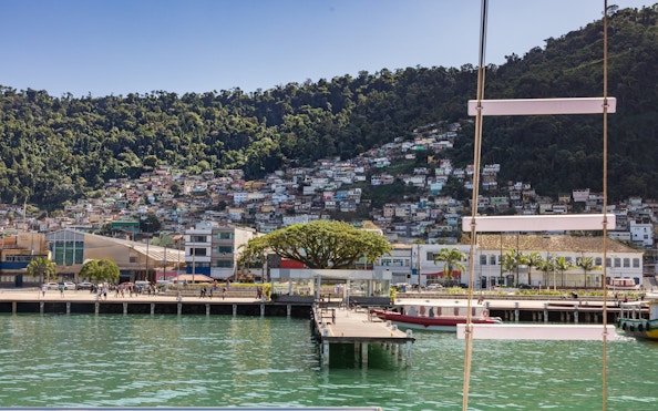 Tourist catamaran in Angra dos Reis bay, Rio de Janeiro, with hillside houses in view.