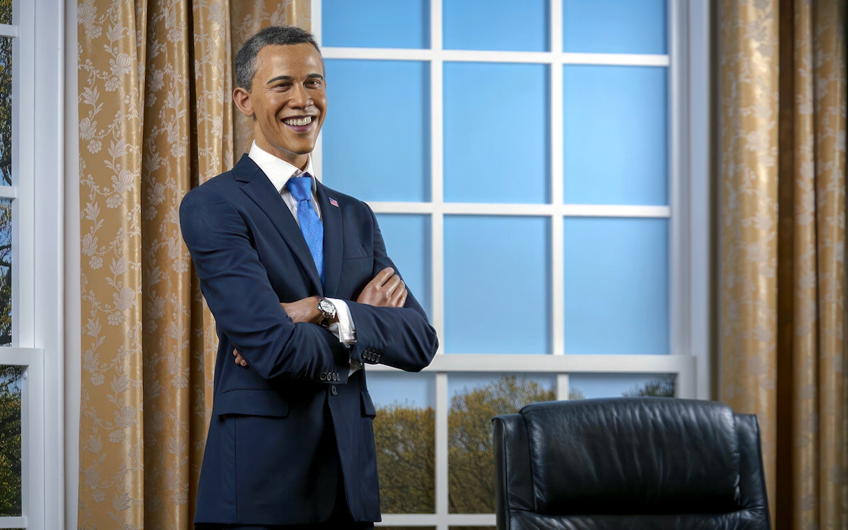 Wax figure of a smiling man in a suit at Madame Tussauds, Tokyo.