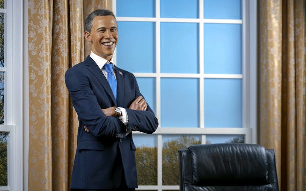 Wax figure of a smiling man in a suit at Madame Tussauds, Tokyo.