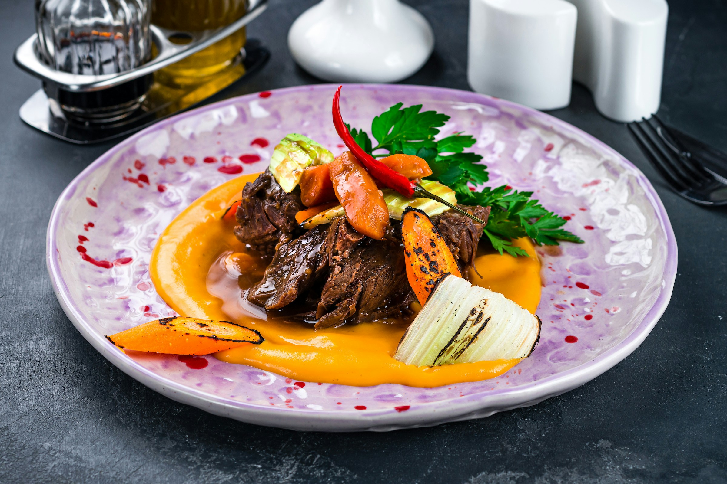 Veal cheeks dish with herbs and sauce, Italian cuisine.