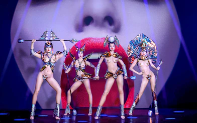 Performers in elaborate costumes on stage at Paradis Latin show, Paris.