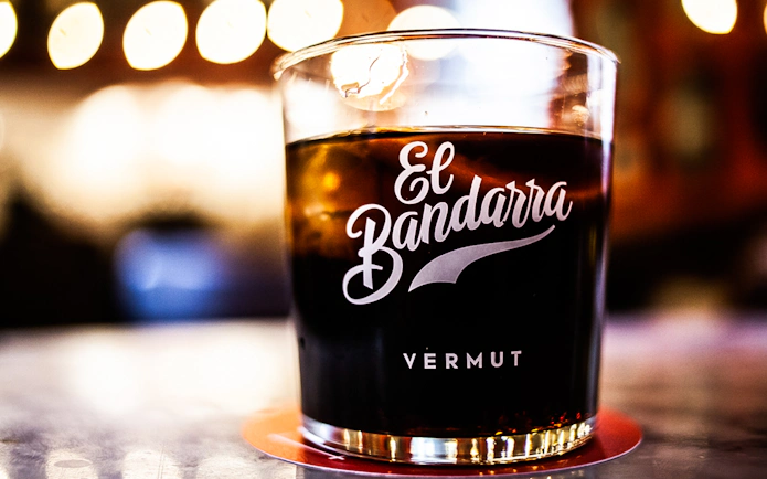 Glass of El Bandarra vermut on a table during La Barceloneta food tour.