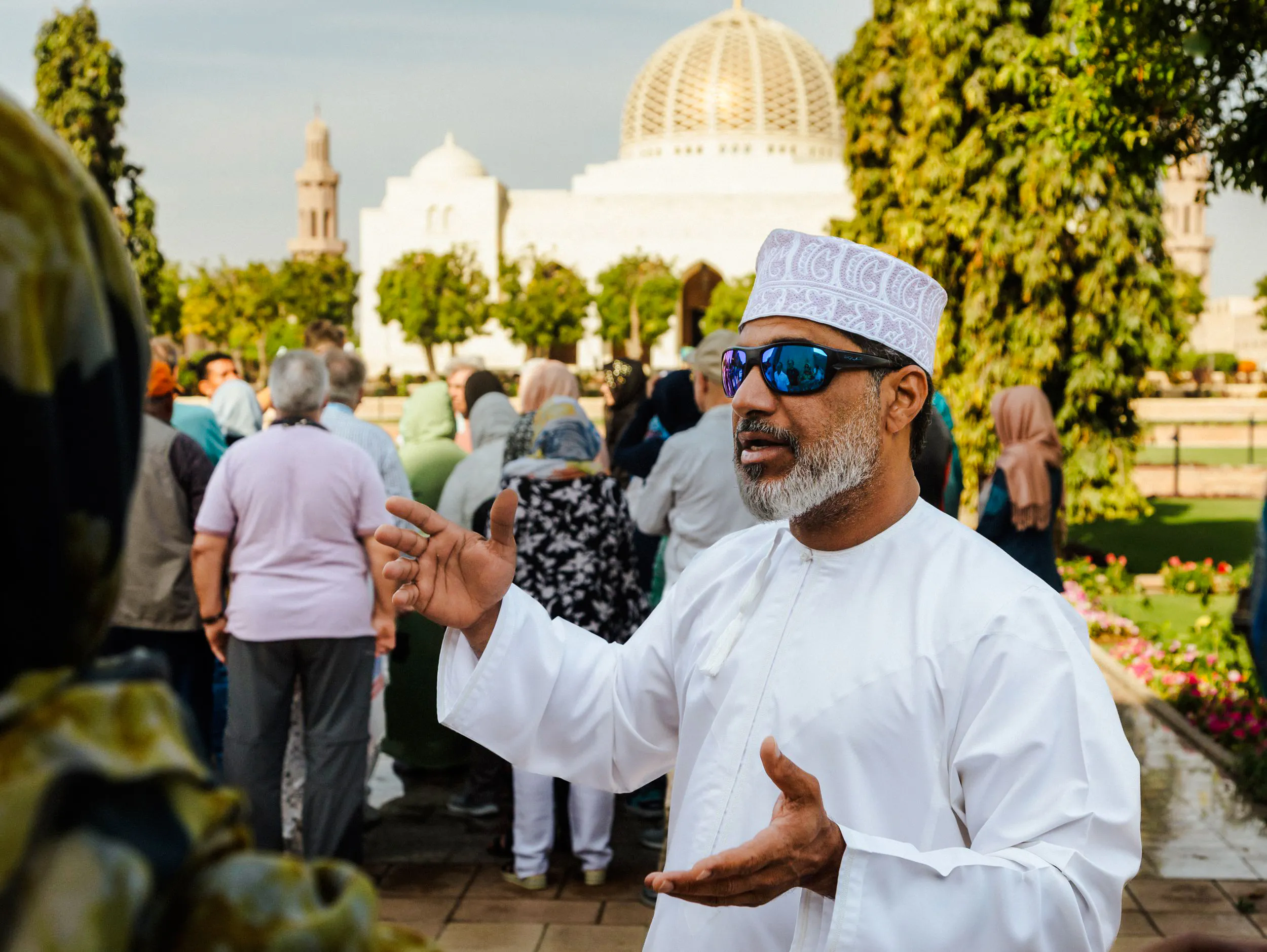 Tour guide leading a group at Sultan Qaboos Grand Mosque, Muscat.