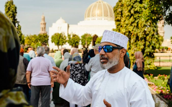 Tour guide leading a group at Sultan Qaboos Grand Mosque, Muscat.