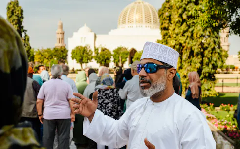 Tour guide leading a group at Sultan Qaboos Grand Mosque, Muscat.