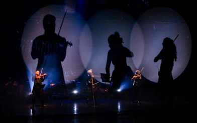 Musicians performing Vivaldianno The SHOW with dramatic lighting at Theatre Hybernia, Prague.