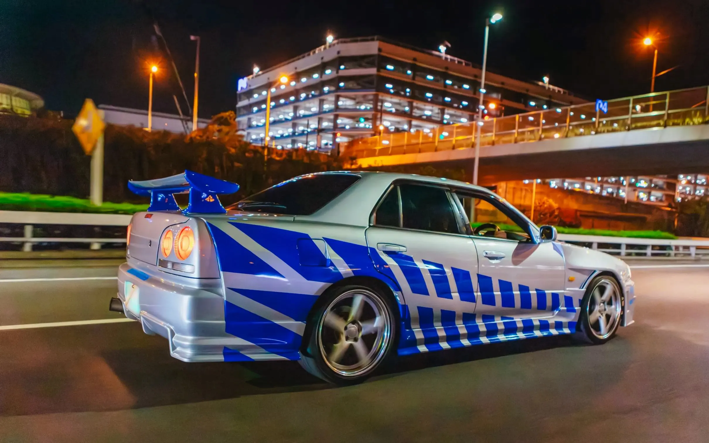 Car drifting on Tokyo street at night during Fast & Furious Tokyo Drift III Experience.