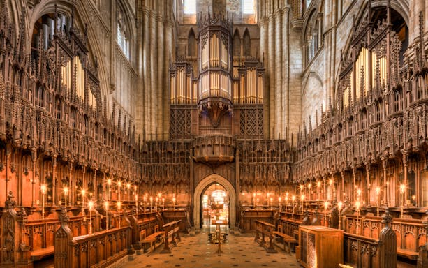Interior of the Cathedral of Barcelona showcasing ornate wooden choir stalls and grand organ.