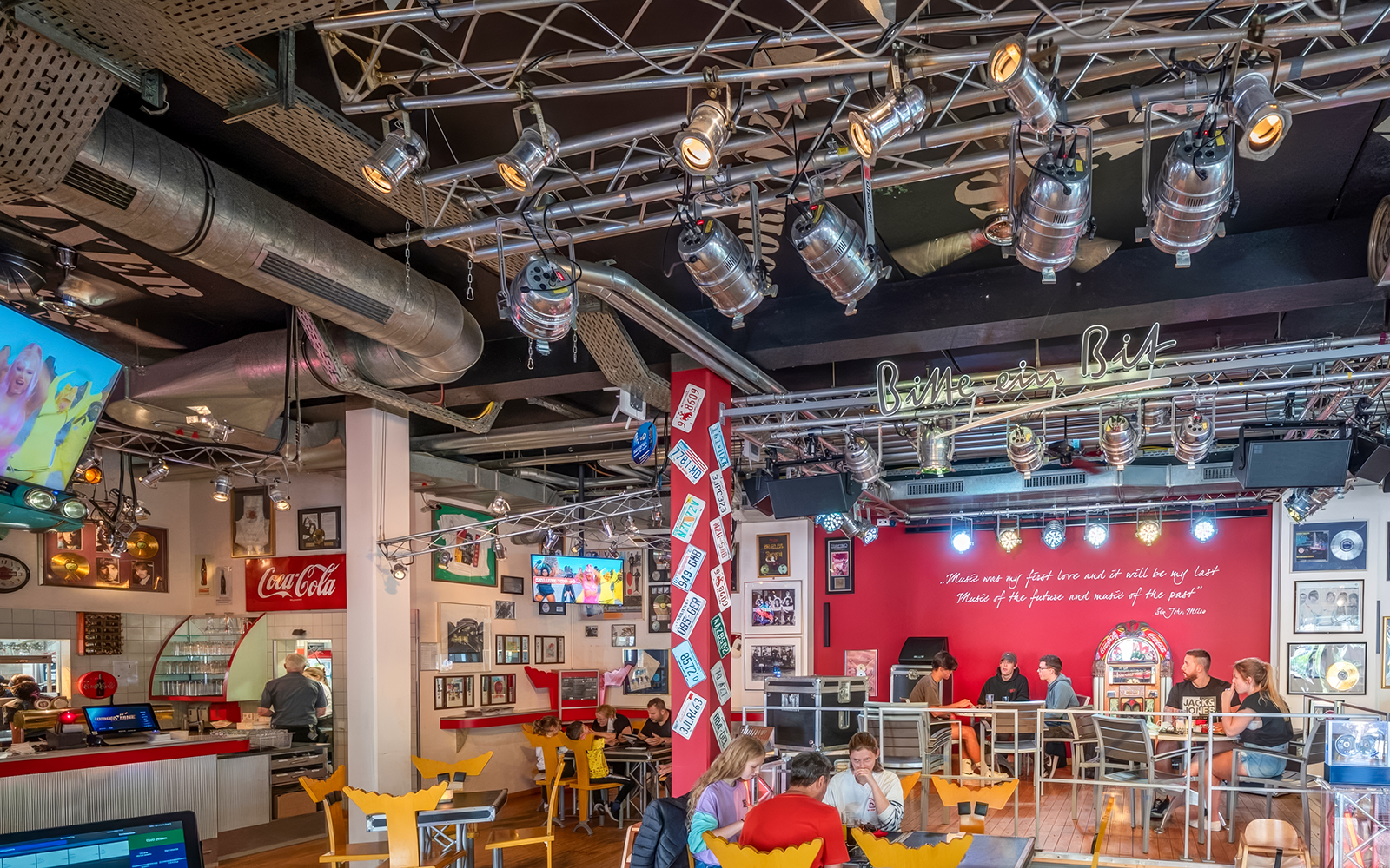 Indoor dining area at Europa-Park with guests seated, vibrant decor, and stage lighting.