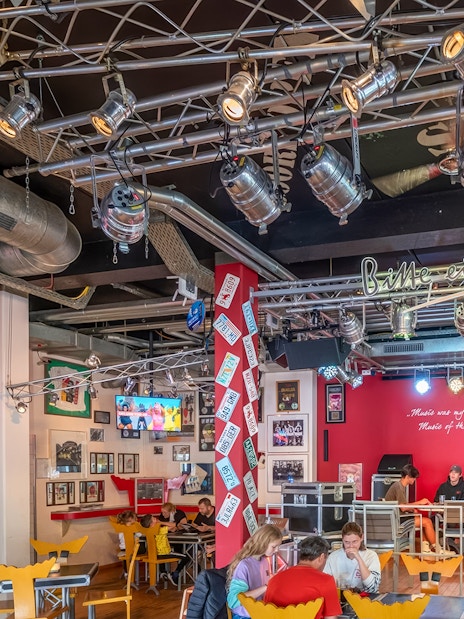 Indoor dining area at Europa-Park with guests seated, vibrant decor, and stage lighting.