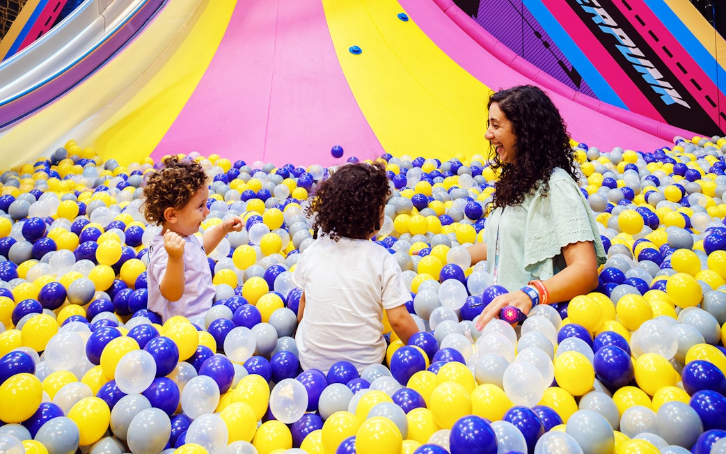 Children and adult playing in a colorful ball pit at Loco Bear entertainment hub.