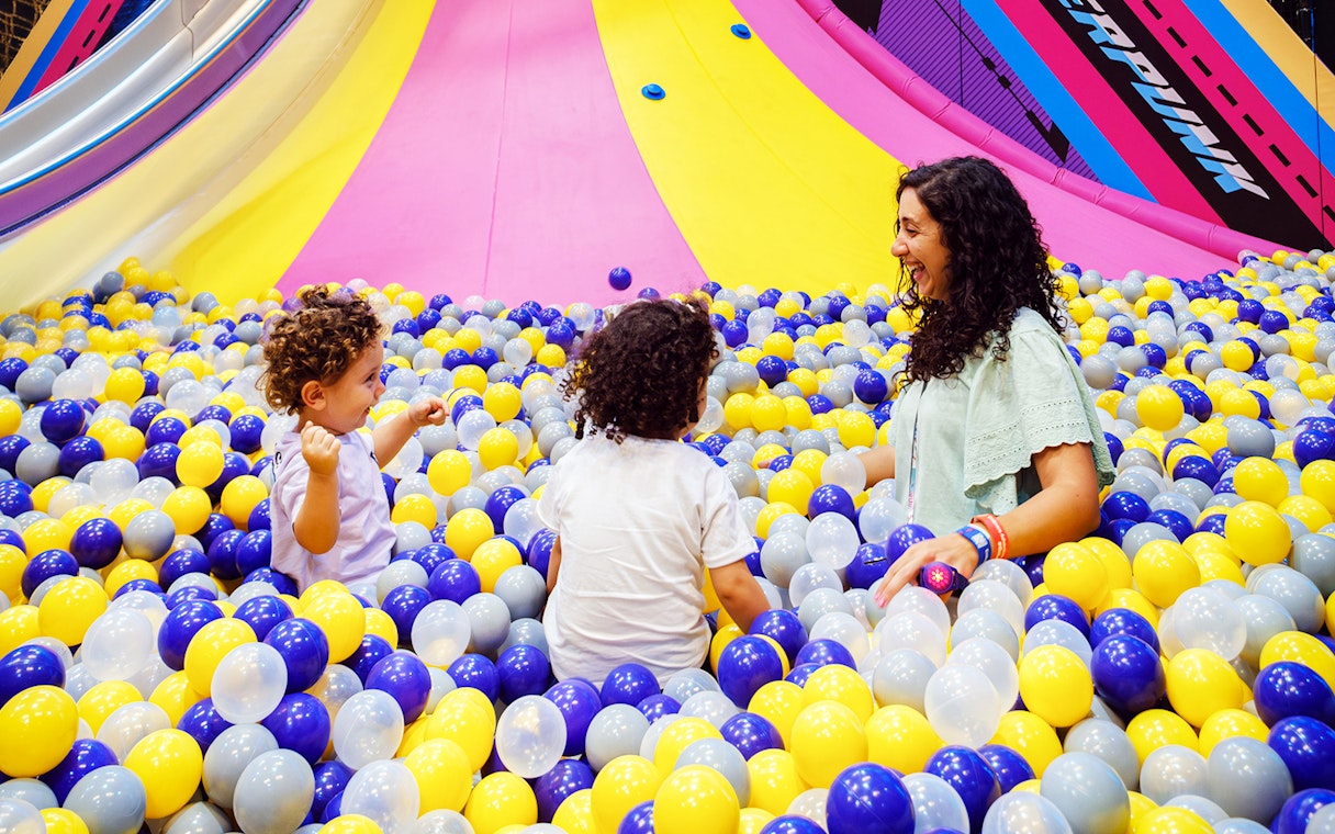 Children and adult playing in a colorful ball pit at Loco Bear entertainment hub.