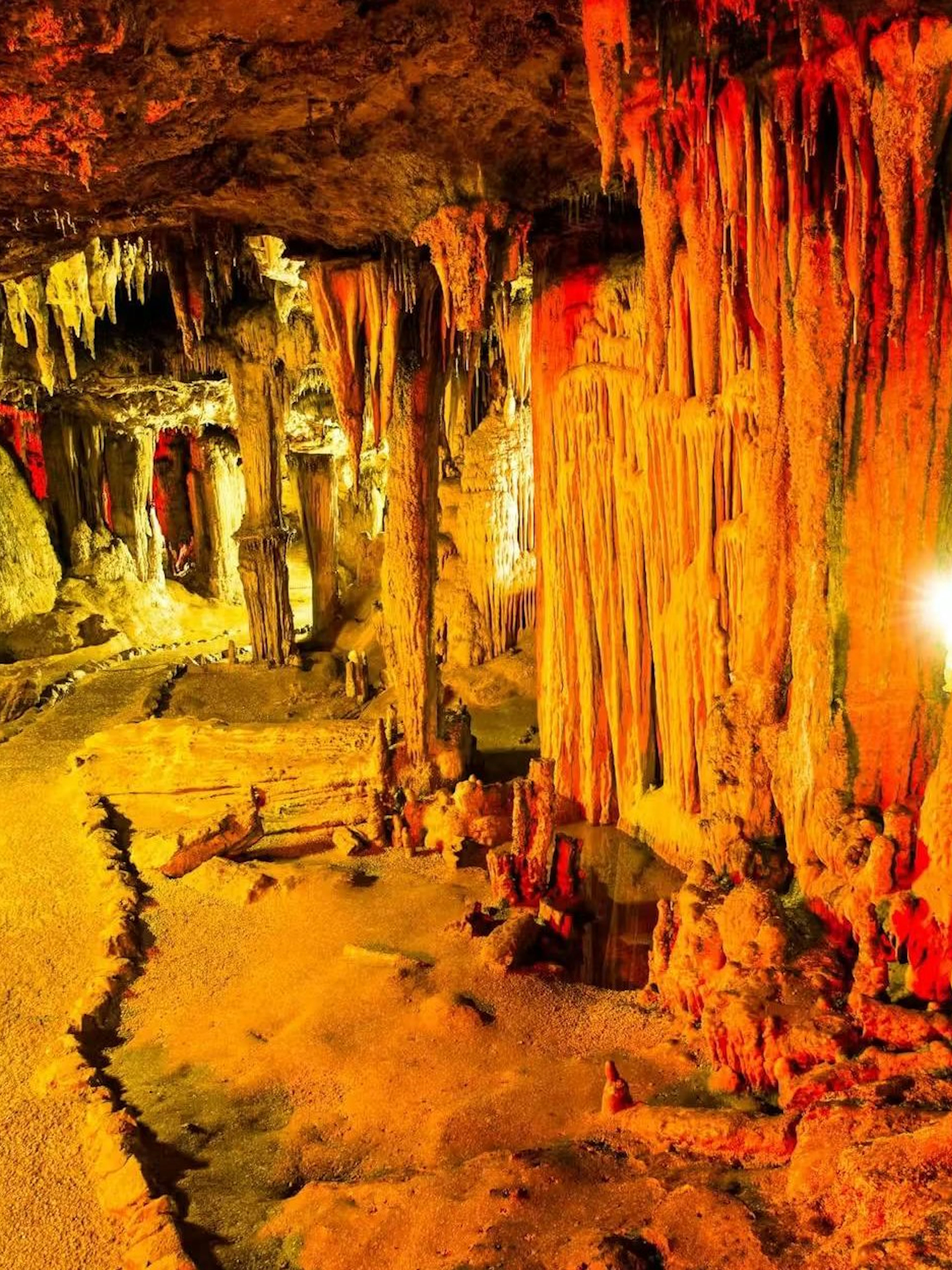 Stalactites and stalagmites in illuminated chamber of Nerja Caves, Spain.
