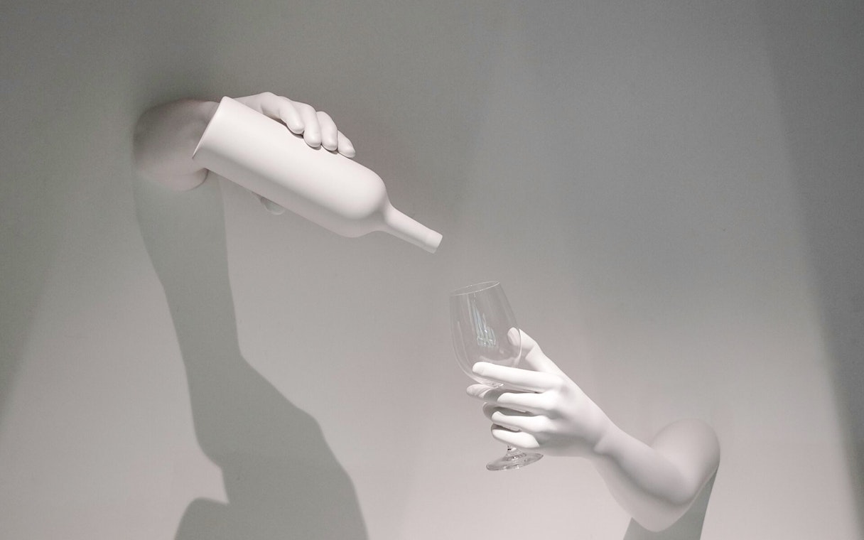 Hands pouring wine into a glass, representing The Wine Experience.
