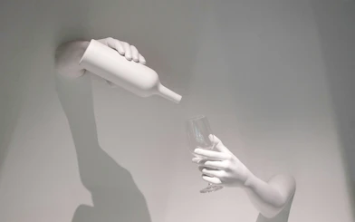 Hands pouring wine into a glass, representing The Wine Experience.
