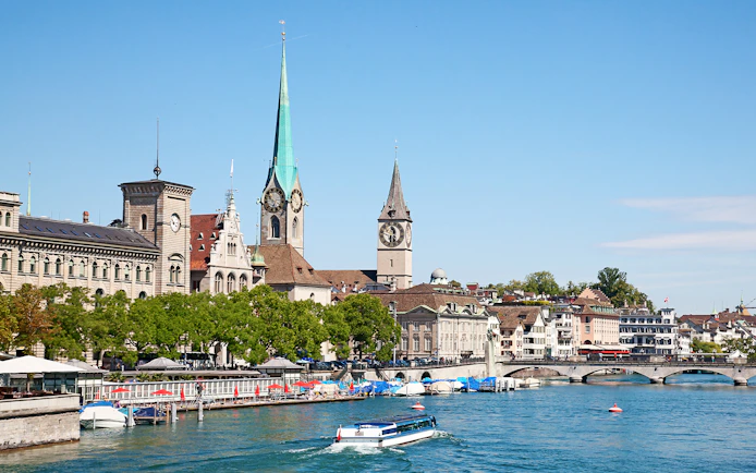 Boat on Lake Zurich with city skyline and historic buildings, Zurich, Switzerland.