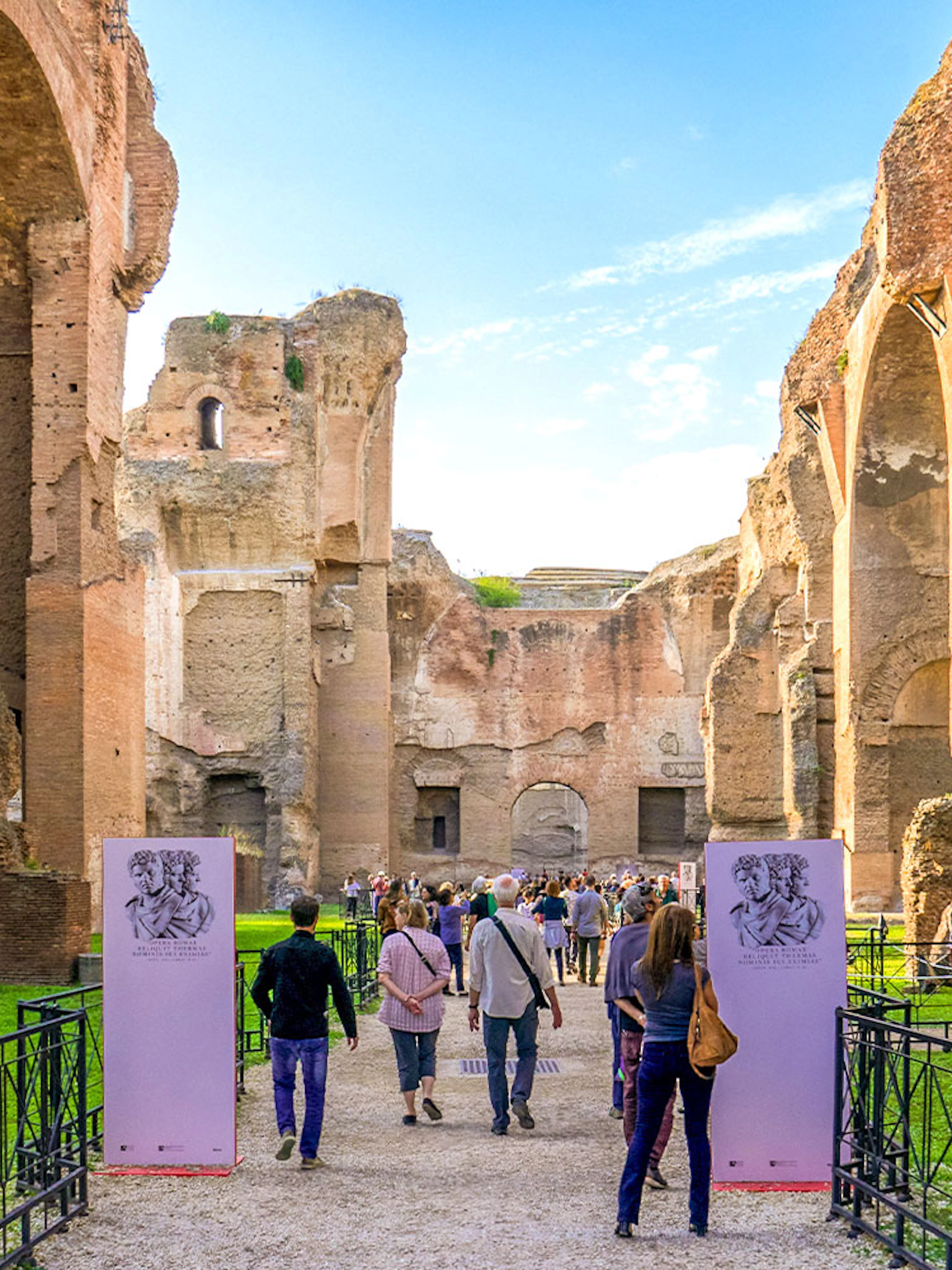 Tourists walking through ancient ruins at Baths of Caracalla, Rome.
