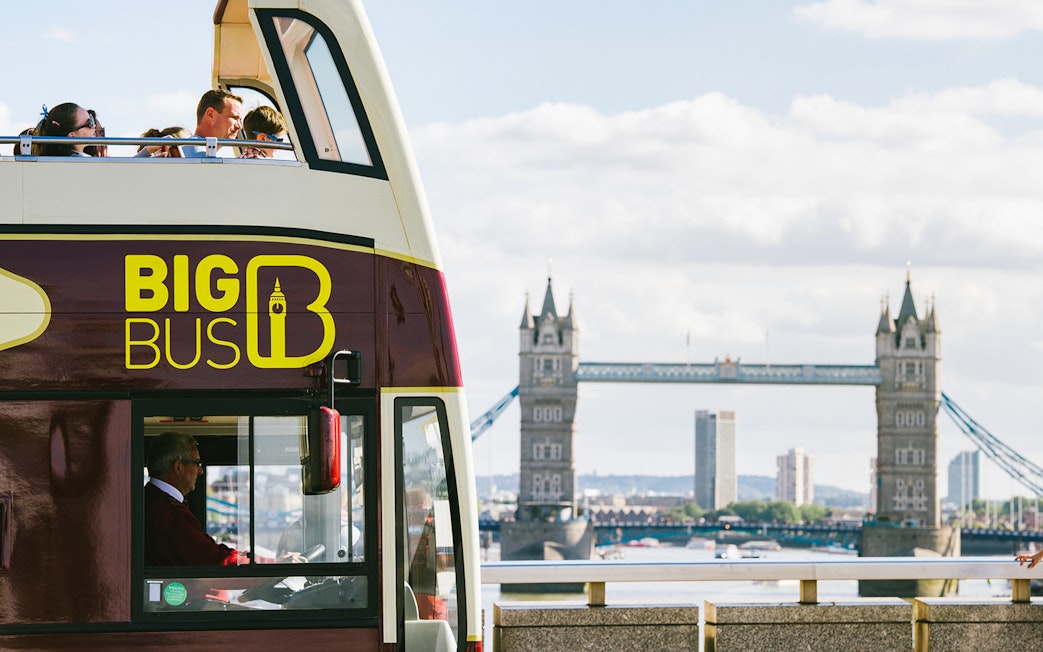 Big Bus tour near Tower Bridge with Thames River view in London.