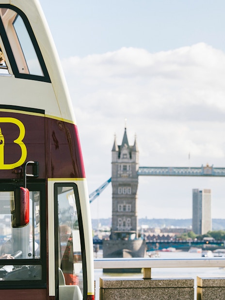 Big Bus tour near Tower Bridge with Thames River view in London.