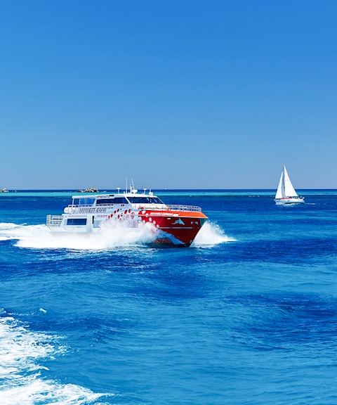 Ferry and sailboat on turquoise waters near Rottnest Island, Western Australia.
