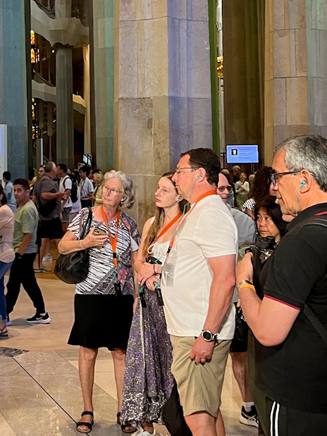 Tour guide explaining Sagrada Familia details to tourists inside the basilica.