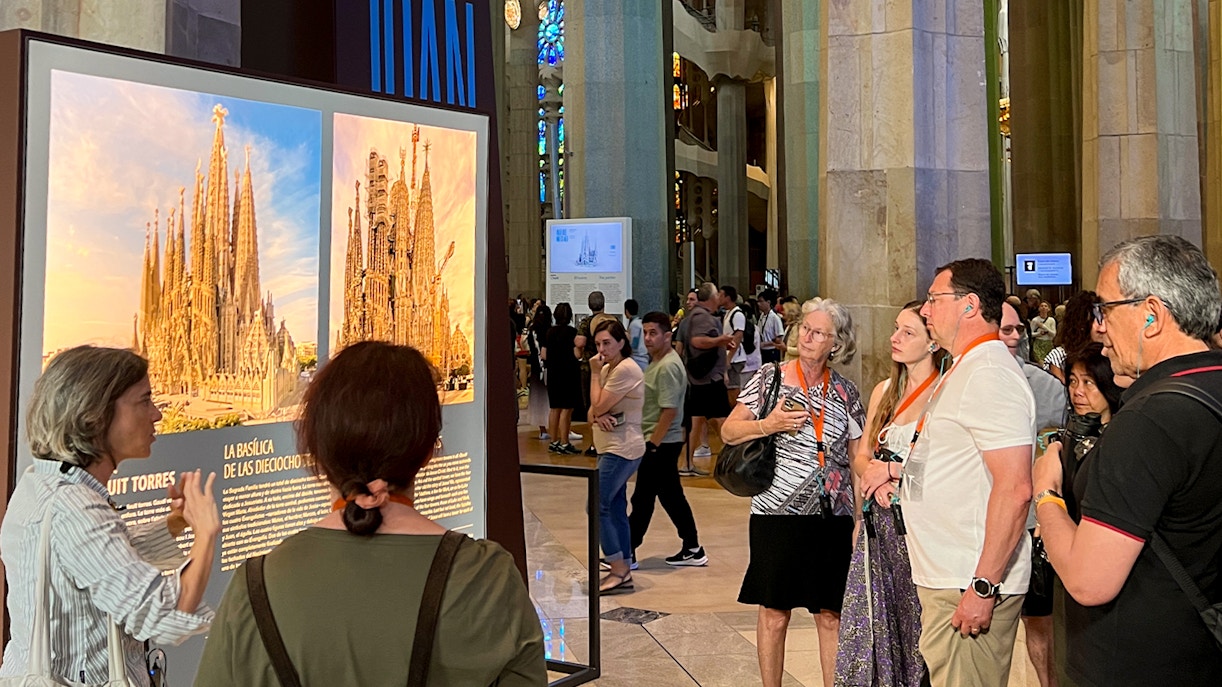 Tour guide explaining Sagrada Familia details to tourists inside the basilica.