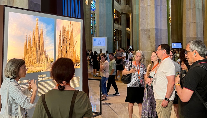 Tour guide explaining Sagrada Familia details to tourists inside the basilica.
