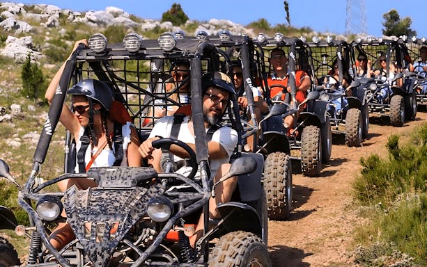 Group driving buggies on a dirt trail during Alanya Buggy Safari tour.