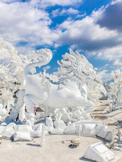 White dragon sculpture at Frost Magical Ice of Siam, Thailand, under a blue sky.