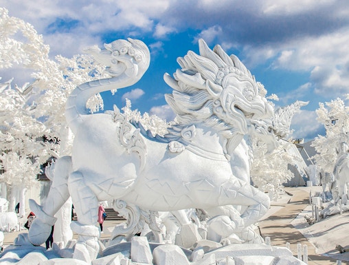 White dragon sculpture at Frost Magical Ice of Siam, Thailand, under a blue sky.