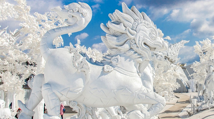 White dragon sculpture at Frost Magical Ice of Siam, Thailand, under a blue sky.