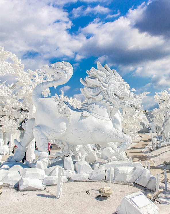 White dragon sculpture at Frost Magical Ice of Siam, Thailand, under a blue sky.