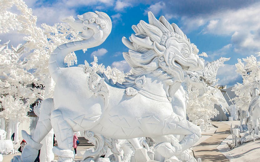 White dragon sculpture at Frost Magical Ice of Siam, Thailand, under a blue sky.