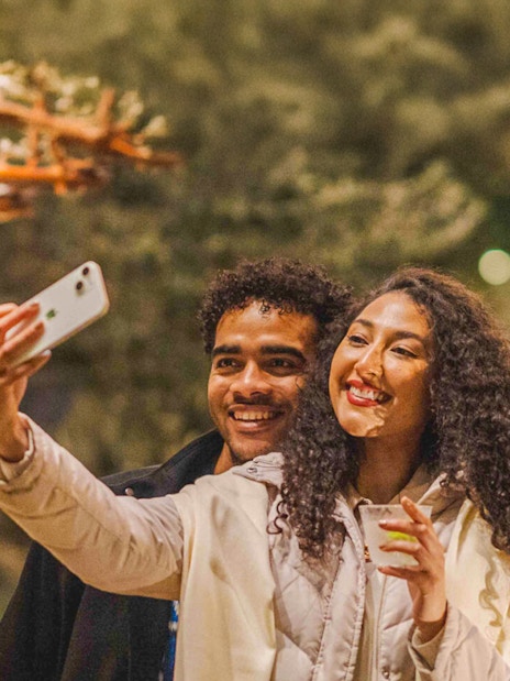 Visitors enjoying drinks and taking a selfie at New York Botanical Gardens.