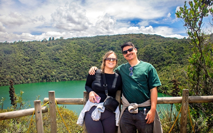 Visitors at Guatavita Lake, Colombia, with lush greenery in the background.