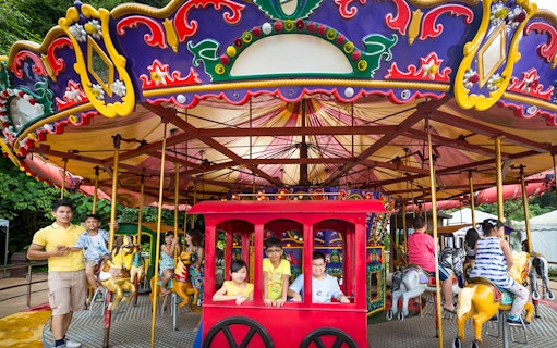Children enjoying a colorful carousel ride at Sunway Lost World of Tambun.