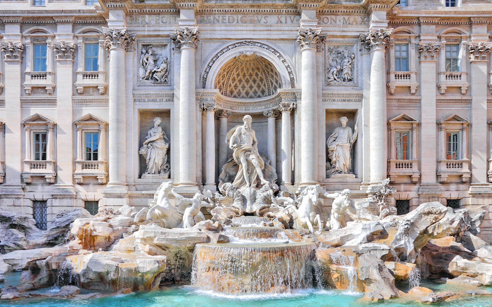 Trevi Fountain in Rome with ornate sculptures and cascading water.