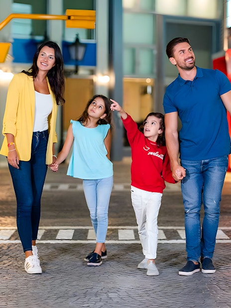 Family walking through KidZania Abu Dhabi, children pointing at attractions.