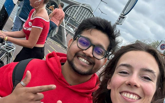 People smiling near Amsterdam Central Station during a city exploration game.