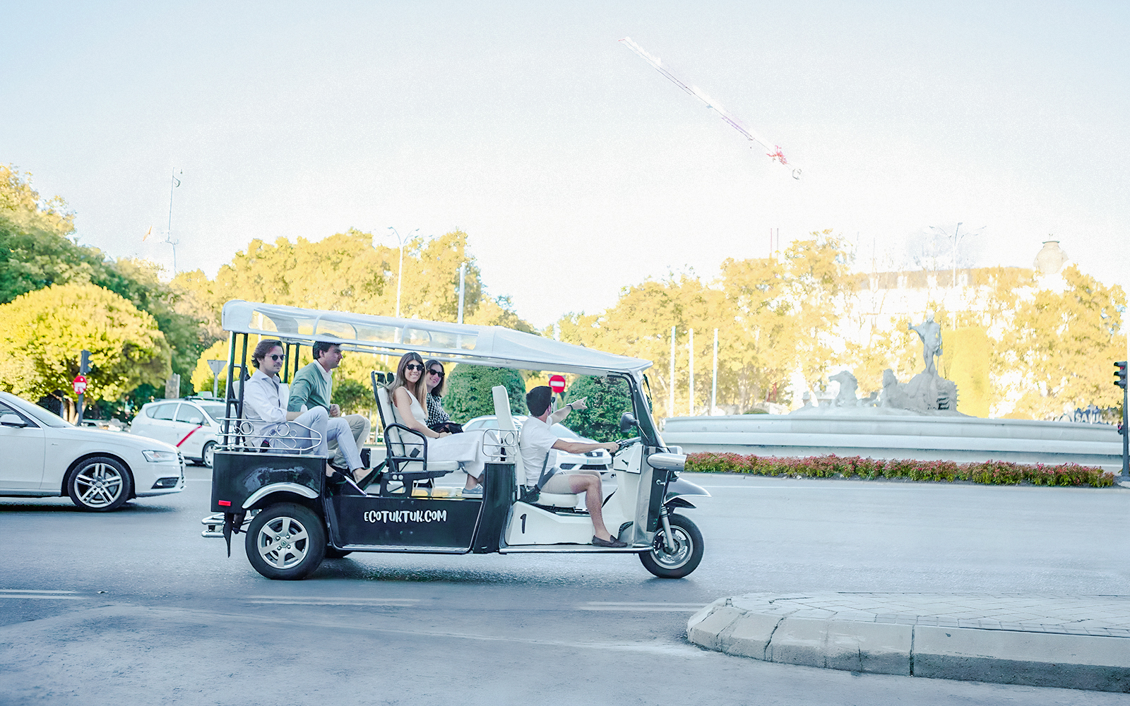 Electric tuk-tuk tour in Madrid with Fountain of Cibeles and Palacio de Cibeles in background.
