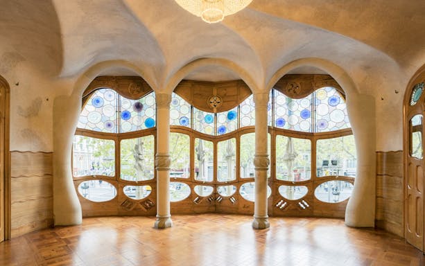 Stained glass windows and curved columns inside Casa Batlló, Barcelona.