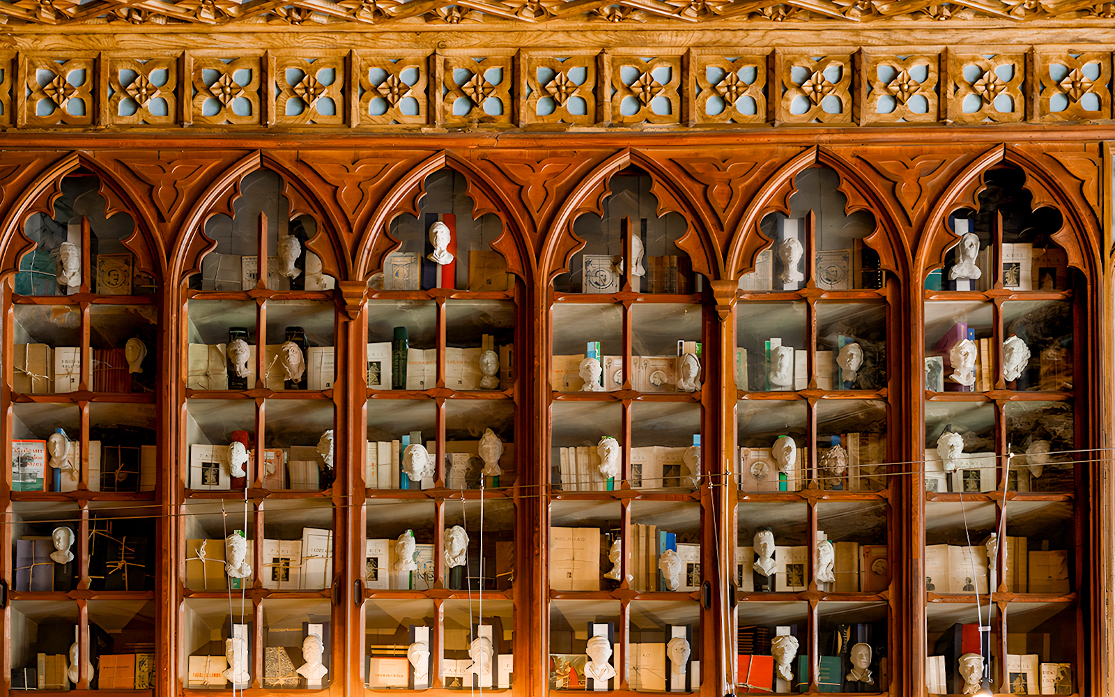 Lello Library ornate wooden bookshelves with busts and books, Porto, Portugal.