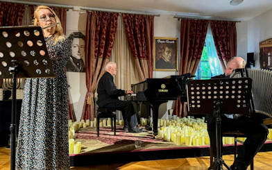 Klezmer musicians performing in Krakow concert hall with piano and flute.