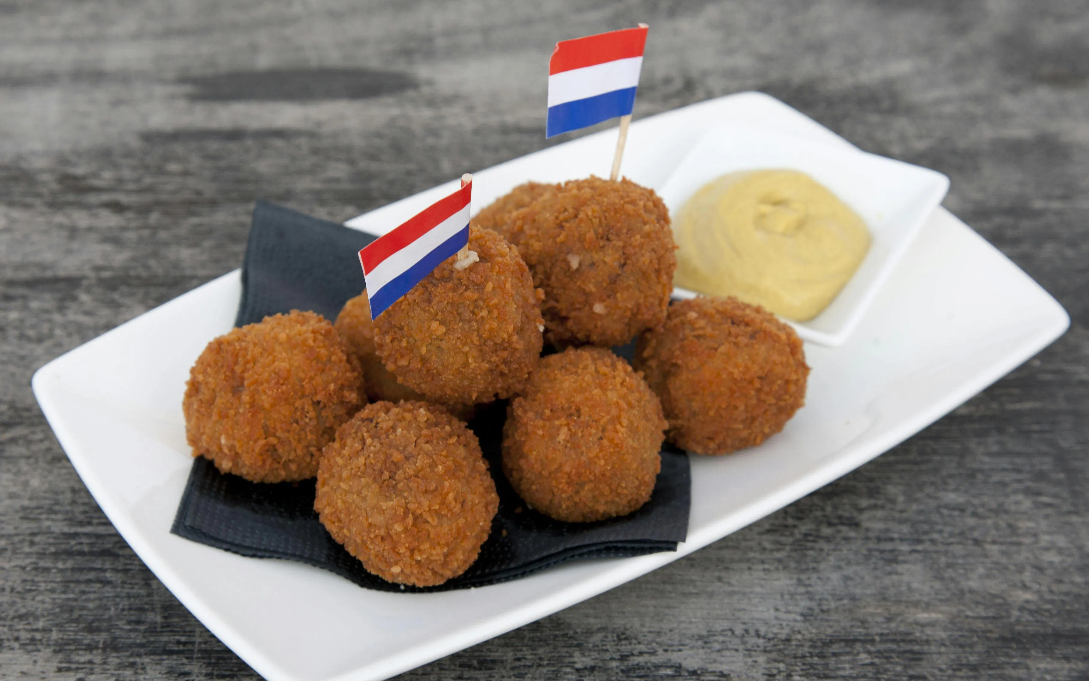 Dutch bitterballen with mustard on a plate, Haarlem food tour.