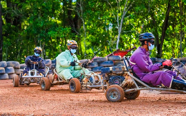 People racing go-karts at Batam Adventure Park track.