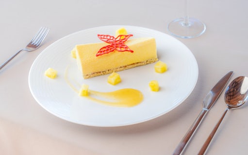 Dessert served on Bateaux Mouches Seine River cruise, featuring a yellow mousse with pineapple and sauce.