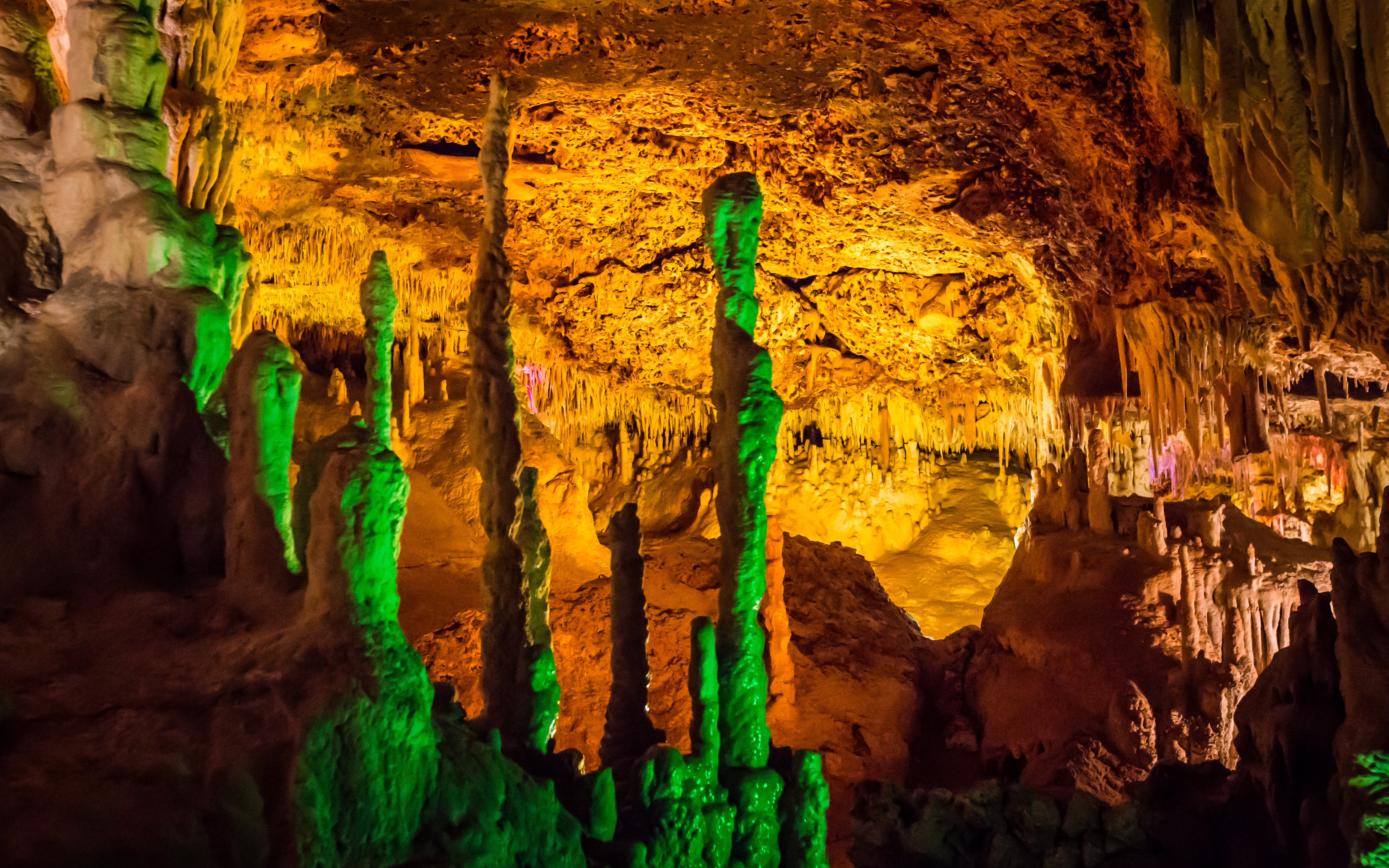 Stalactites and stalagmites in Hams Caves, Mallorca, illuminated with colorful lights.