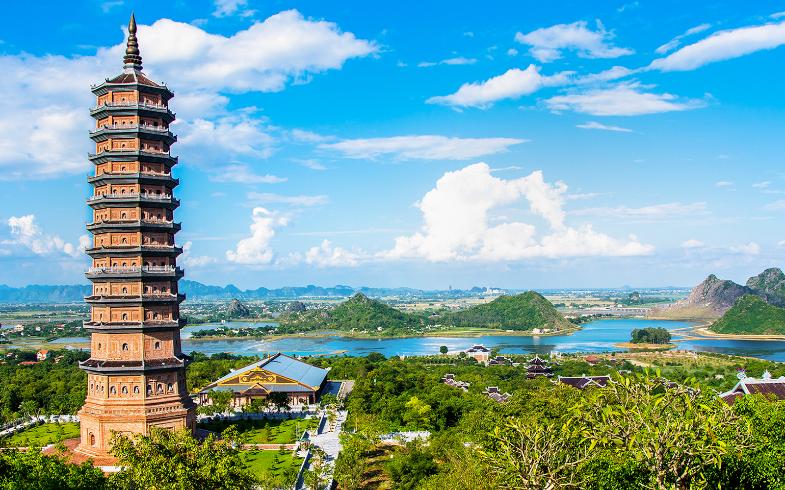 Bai Dinh Pagoda tower with lush landscape and mountains in Ninh Binh, Vietnam.