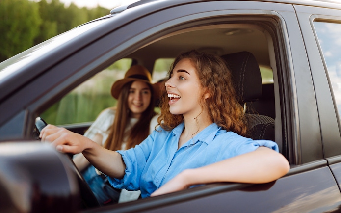 Two women smiling in a car during a road trip in Langkawi.