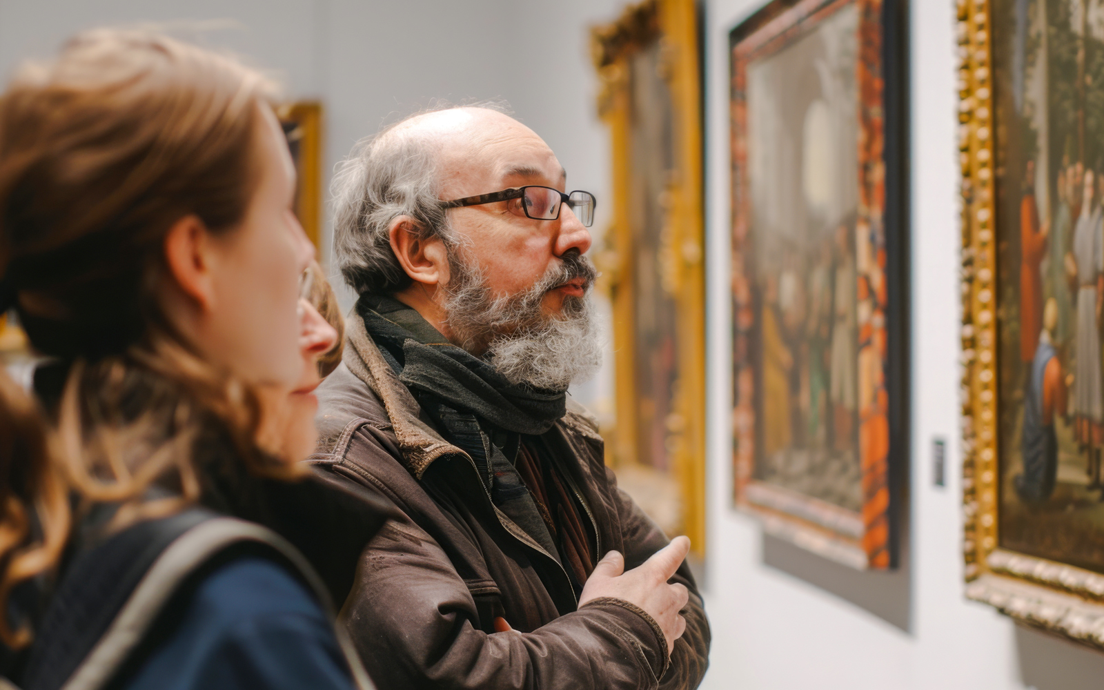 Guests observing paintings at an art gallery.